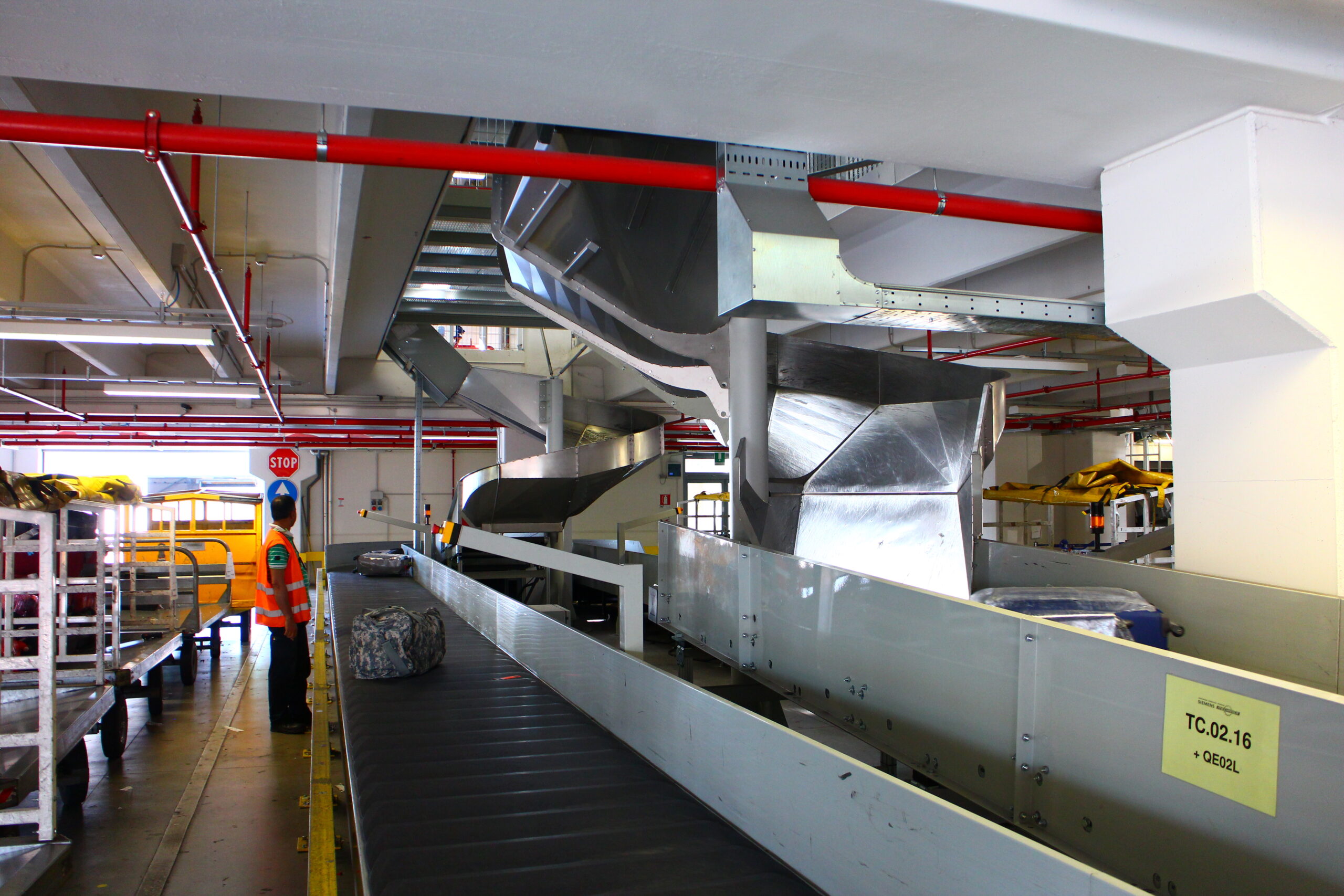 Type 9012 make-up carousel loading baggage carts in a baggage hall