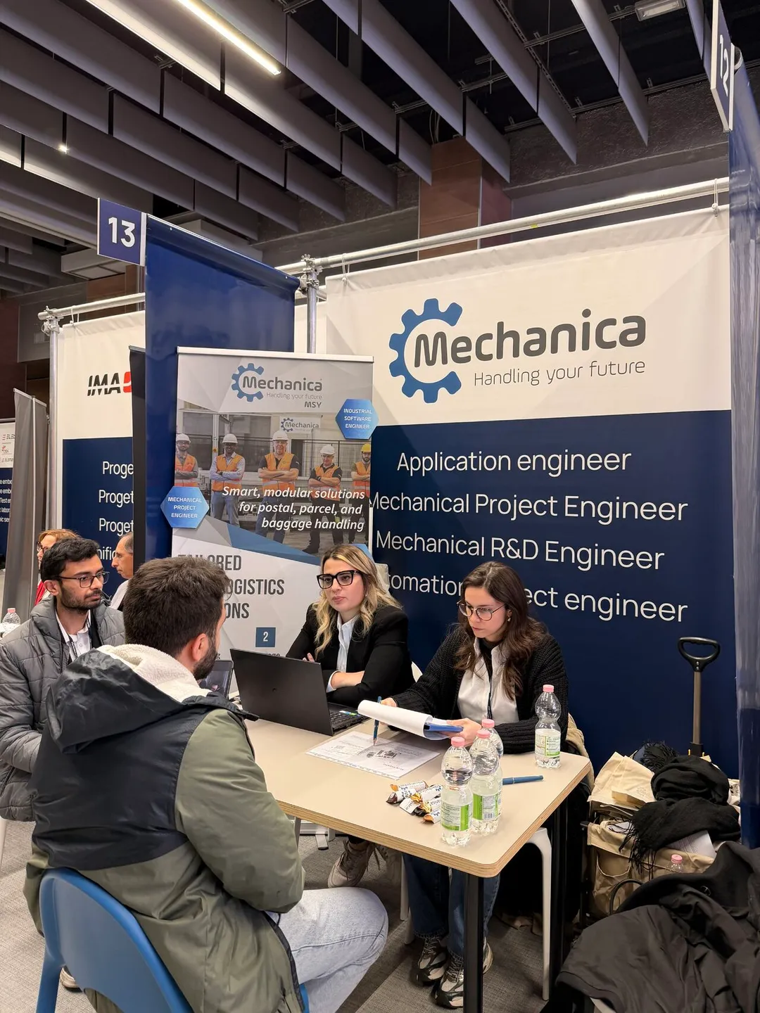 Candidates talking with the Mechanica team at the booth