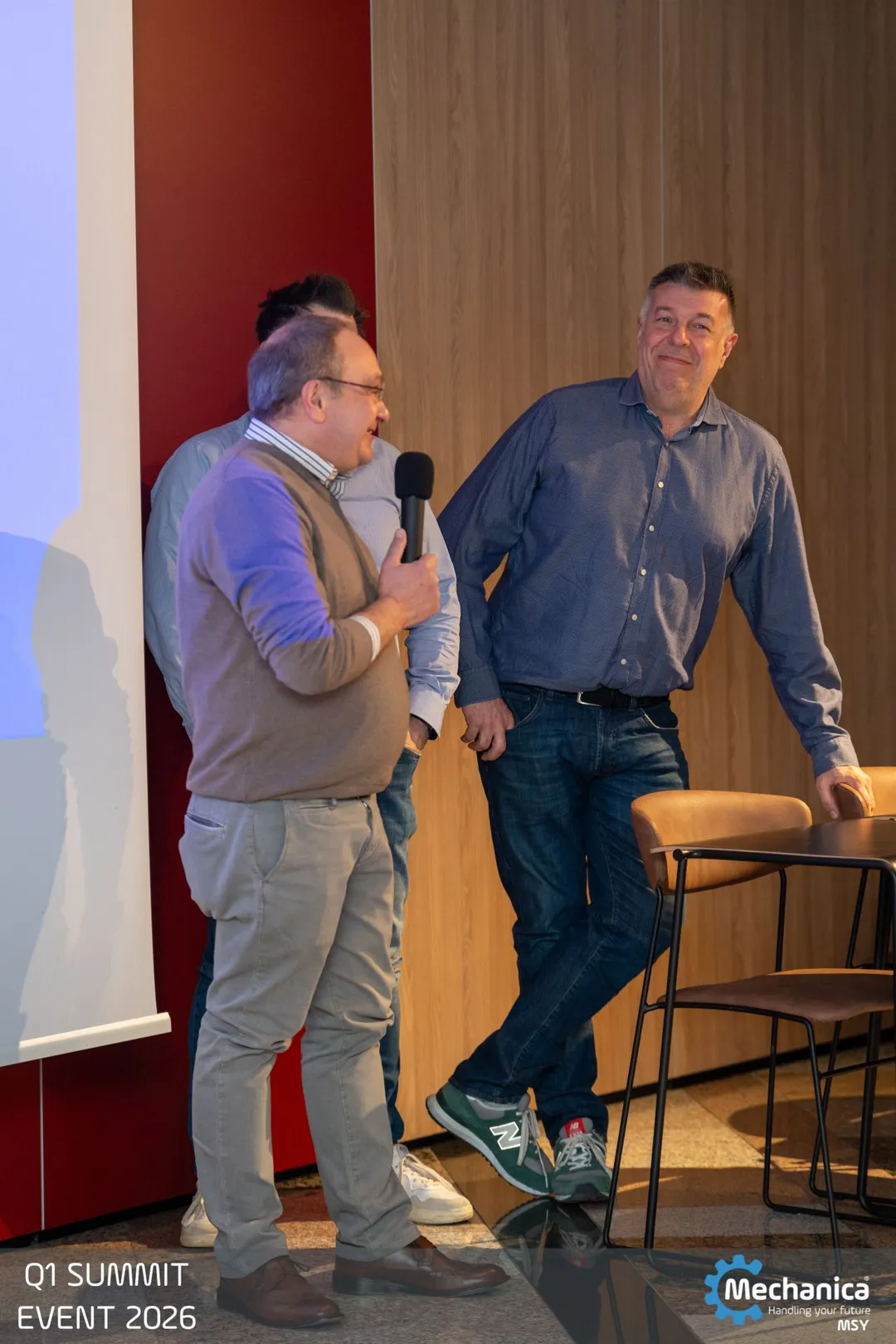 Two colleagues sharing the microphone on stage