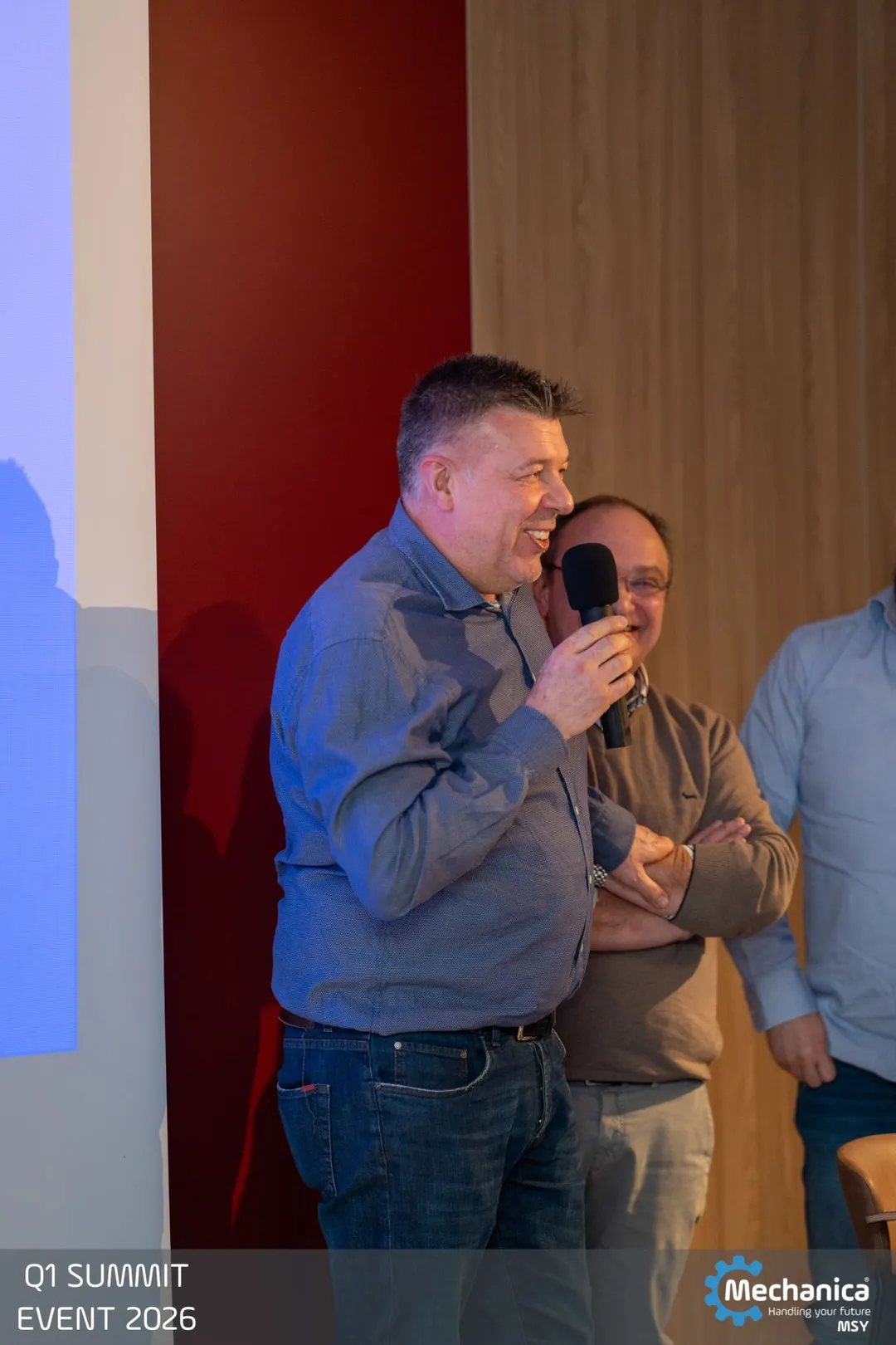 Colleague laughing while holding the microphone